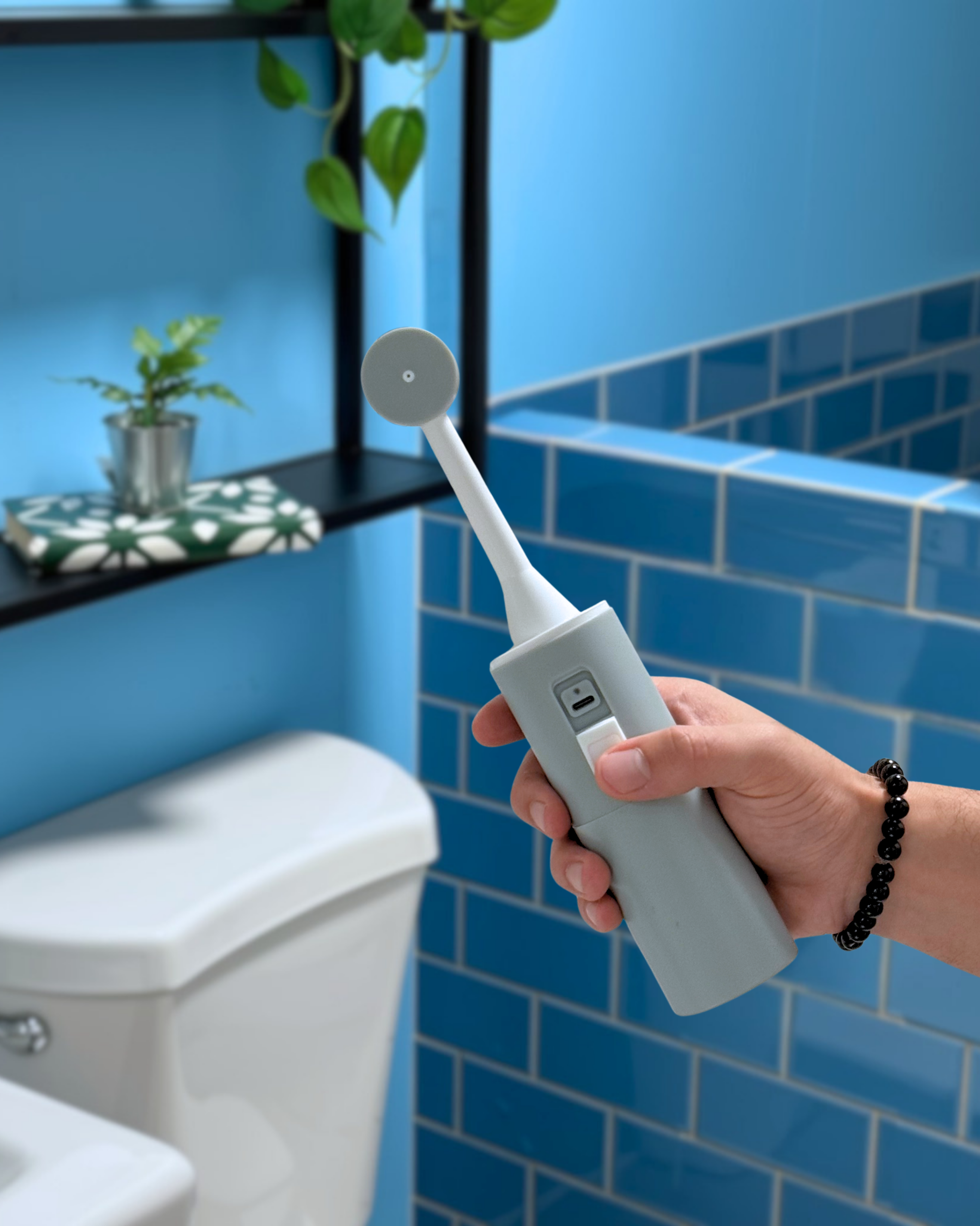 Portable bidet being used in bathroom showing its USBC port