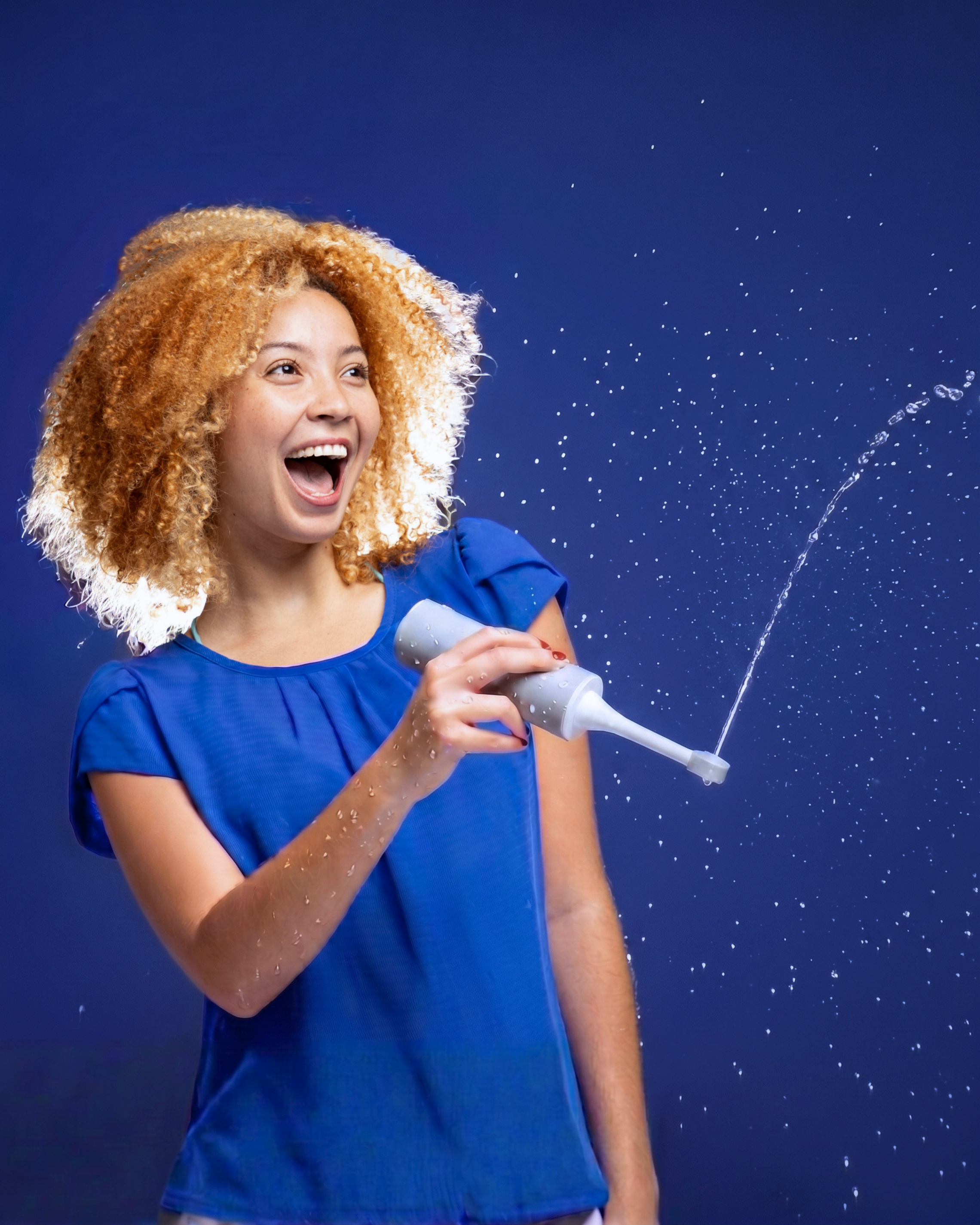 Woman using portable bidet outdoors demonstrating water spray